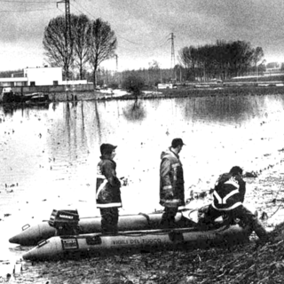 Nello scatto del Gruppo Fotografico Albese la ricerca dei dispersi sulle rive del Tanaro all'indomani dell'ondata di piena che travolse la capitale delle Langhe