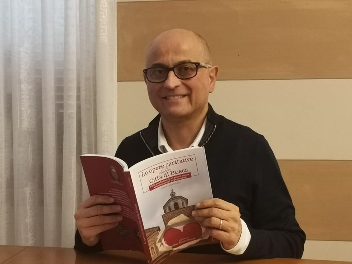 L'autore Luca Gosso con il libro &quot;Le opere caritative della città di Busca. Dalle Confraternite ai giorni nostri, settecento anni di generosità&quot;