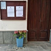 I fiori lasciati nel piccolo recipiente fuori dal cimitero di Monterosso Grana