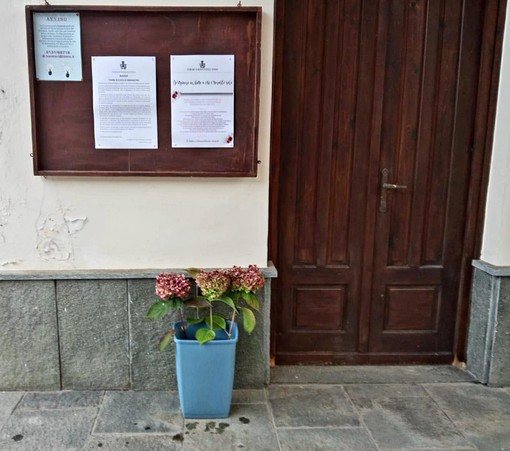 I fiori lasciati nel piccolo recipiente fuori dal cimitero di Monterosso Grana
