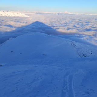 Nella foto di Neil Conte è stata immortalata l'ombra del Mondolé proiettata sulle nubi, con il Monviso innevato che si staglia in lontananza