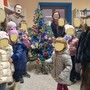 Il sindaco di Rifreddo Elia Giordanino con Erika Mustazzo e i bambini che hanno realizzato l'albero di Natale della biblioteca comunale