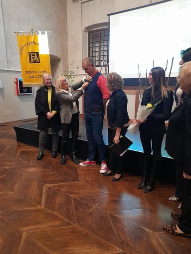 Ingresso ufficiale di Giuseppe Tommasiello nel club Zonta Saluzzo. &quot;La spillatura&quot; da parte della presidente dell'Area 3 Distretto 30 e della presidente Zonta Saluzzo Tiziana Somà accanto alla madrina Anna Madria Gavatorta