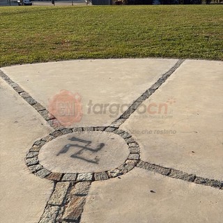 Una svastica disegnata a terra, in cima alla collinetta del parco